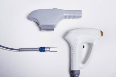 Düz beyaz arka plana yerleştirilen dermo-estetik tedavilerin uygulanması için farklı aksesuar ve saplar