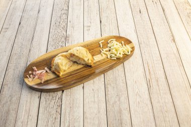 Arjantin empanadası pişmiş jambon ve erimiş peyniri uzun ahşap tabakta