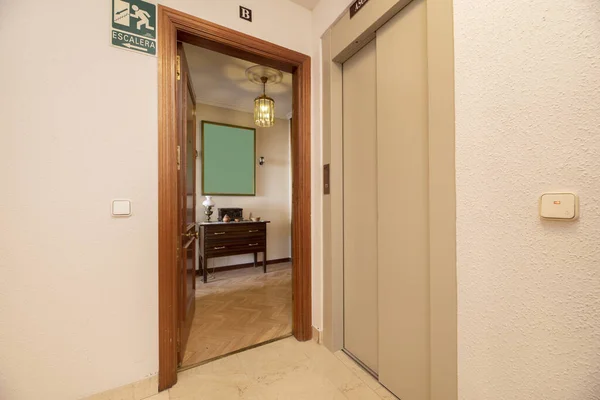 アパートの着陸にエレベーターの金属摺動ドアの横にあるオープンアパートの入り口 — ストック写真