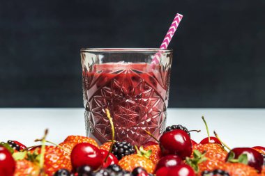 Bir bardak kırmızı meyve arınma suyu ve kirazlı, böğürtlenli ve çilekli