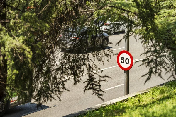 Circular speed limit warning sign on an urban avenue
