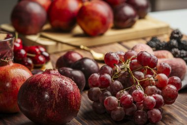Bazı narlar su damlacıklarıyla ıslanır, benzer tonlarda meyveler, üzüm ve orman meyveleriyle birlikte.