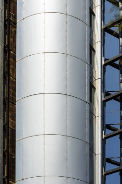 Madrid 'deki Moncloa deniz fenerinde sabah güneşiyle aydınlatılmış asansör rehberli dairesel metalik yapı.