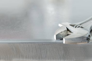 Parlak metal bir yüzey üzerinde küçük çelik bir anahtarın kafası.