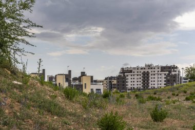 Düşük bitki örtüsü olan bir kanaldan görülen küçük bir yerleşim alanı.