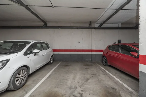 Parę Samochodów Zaparkowanych Pomiędzy Pustym Garażem — Zdjęcie stockowe