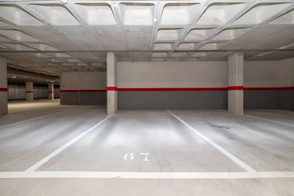 A garage with polished concrete floors and concrete ceilings with the spaces completely empty