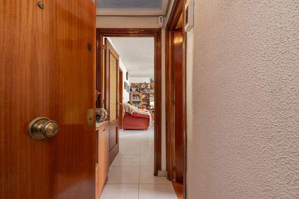 Входной зал жилого дома с бронированной дверью, облицованной сапельным деревом, и входными дверями в другие соответствующие помещения