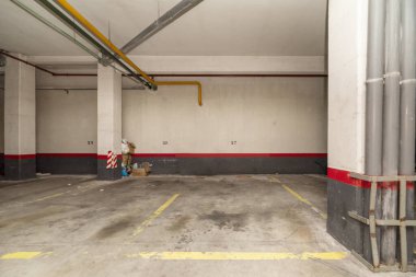 An empty parking space in the basement of an urban residential building clipart