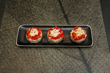 Kırmızı biberli ve morina balıklı üç parçalı uzun bir tepsi.