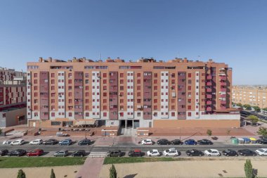 Sokakta araçları park etmek için geniş yolları ve alanı olan şehirli arı kovanına benzer konut binalarının kentleşmesi