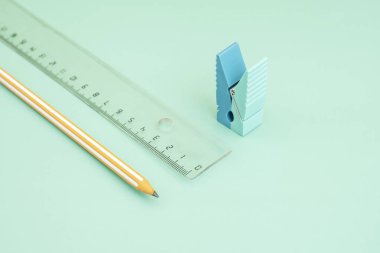 Cetvelli turuncu bir grafit kalem ve mandal şeklinde silgi.