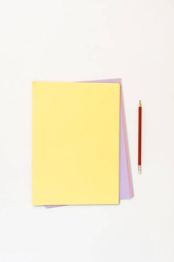 Bir ucunda silgi olan bir kaç tomar farklı renkli kağıt.