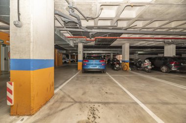 Beyaz boya ile sınırlanmış bir sürü boş alanı olan bir yeraltı otoparkı.