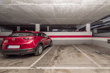 Beton zeminde beyaz boyayla çizilmiş bir sürü boş alanı olan bir yeraltı otoparkı.