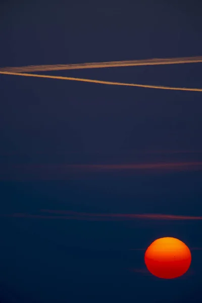 美丽的日出 深蓝色的天空 飞机的尾迹 红色的升起的太阳 — 图库照片