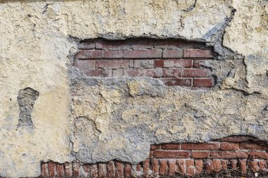 Betonla kaplı eski kil tuğla duvar. 
