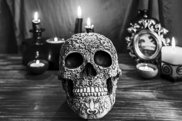 木のテーブルの装飾された頭蓋骨 ろうそくおよび背景が付いている黒くおよび白い生命 — ストック写真