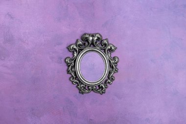 Mor gözenekli yüzeyde küçük gümüş bir çerçeve.