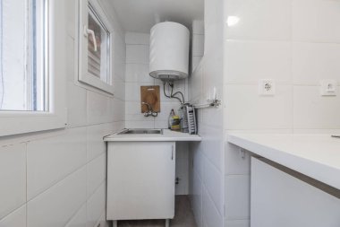 Lavabosu olan küçük bir mutfağın köşesinde. 