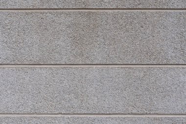 Pürüzsüz yatay çizgileri olan bir beton duvar.