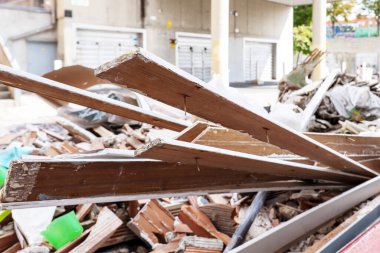 Evdeki yenileme çalışmalarından kalma ahşap ve tuğla atıkları sokaktaki bir konteynırda depolanmış.