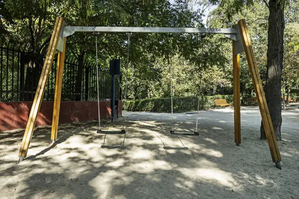 A swing with wooden feet and chains