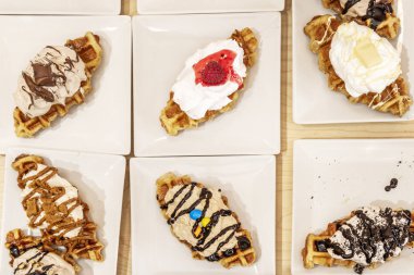 Waffle şekerli, kremalı, şuruplu, çikolatalı ve meyveli tabaklar.