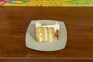 Beyaz bir porselen tabağın içinde bol kremalı Latin tarzı bir pasta.