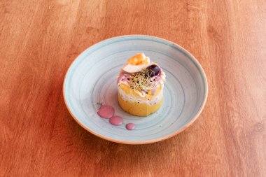 Bu yemek geleneksel olarak sarı patates, limon, sarı biber, haşlanmış yumurta ve siyah zeytin temelinde yapılır.