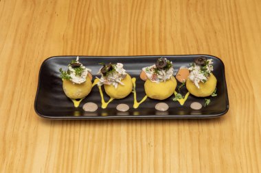 Bu hazırlık, ton balığı, alabalık, tavuk, kabuklu deniz hayvanı veya diğer beyaz et çeşitleri ile doldurulmuş bir neden gibi çeşitli varyasyonları kabul etmektedir. Hafif bir mayonez banyosuyla servis edilir.