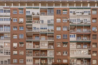 Balkonları, alüminyumu ve cam duvarları olan arı kovanına benzeyen şehir binaları.