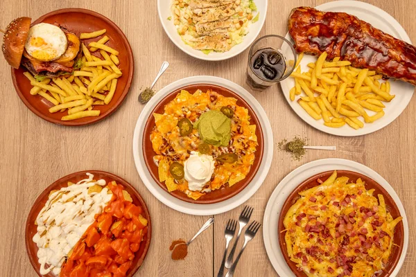 Meksika ya da Tex Meksika usulü fast food yemekleri, yanında sosisli ve peynirli nacho, domuz pastırmalı patates kızartması, hamburger, salata ve barbekü kaburgası.