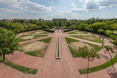 Çeşmeleri, kırmızı çimento ve şehir parkındaki çimlerin olduğu büyük dairesel bir meydanın panoramik görüntüsü
