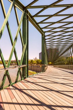 Madrid 'deki Manzanares nehri üzerinde metalik çelik yapısı ve ahşap geçidi olan bir geçit.