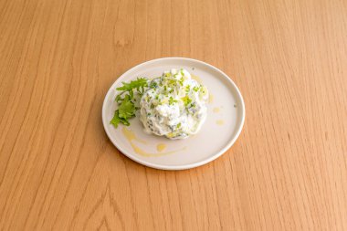  Cack 'in Yunanca versiyonu, salatalık ve yoğurt bazlı sostur, özellikle et ve diğer yemeklerde tüketilir.