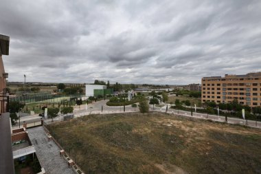 Yağmur bulutu yüklü kış gününde boş arsaların olduğu panoramik yerleşim alanı manzarası