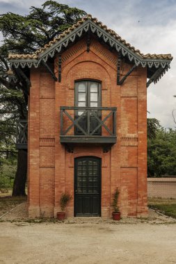 Küçük ahşap bir balkon yeşile boyanmış eski bir tuğla evde ahşap detaylar ve manzaralı bir alanda