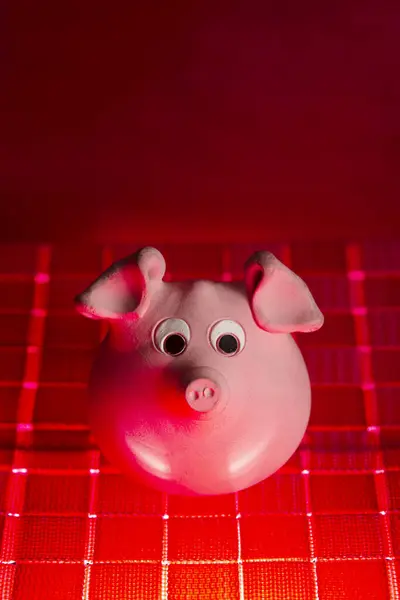 A typical pink clay piggy bank in the shape of a pig