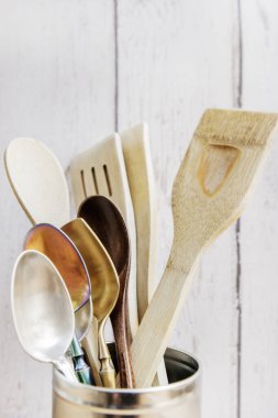 Birkaç çatal ve kaşıkla çeşitli malzemelerden oluşan paslanmaz çelik bir kase.