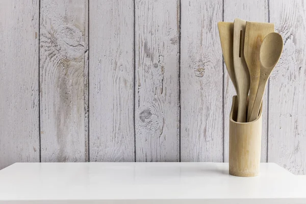 Wooden kitchen utensils inside a bamboo container