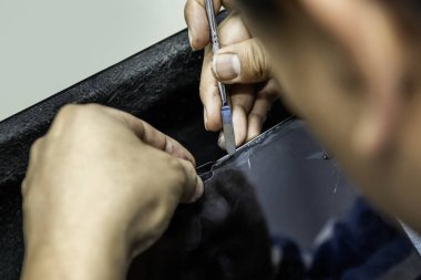 Cep telefonu ve tablet ekipman tamirhanesinden bir teknisyen.