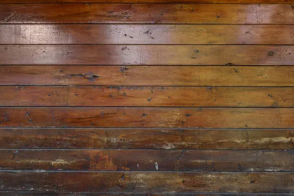 A wall of a wooden cabin made of varnished planks