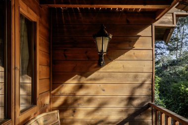 Duvarında siyah lamba olan ahşap bir kulübe duvarı