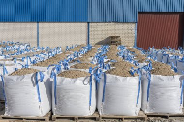 İnşaat için kum dolu bir sürü büyük raffia torbası.