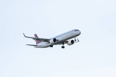 Havaalanı pistine yaklaşmak için iniş takımlarını indiren bir uçak.