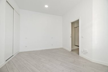 Zemin katta, ahşap zeminli, tavan arası tipi bir evde bir oda. Banyoya giriş ve sürgülü kapılı gardıroplar.