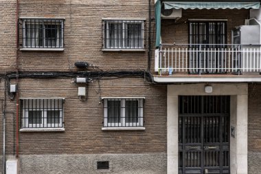 Pencerelerinde hırsızlık karşıtı parmaklıklar olan geleneksel bir şehir konut binası.