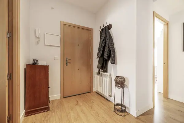 Hallway of a home with armored access door and a coat rack with hanging clothes