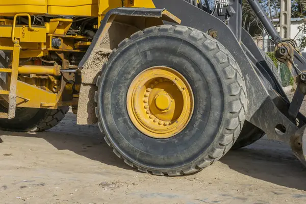 A large rubber tire on the wheel of a civil works bulldozer